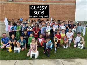 kids outside of the school building with their jugs of "Classy Suds"